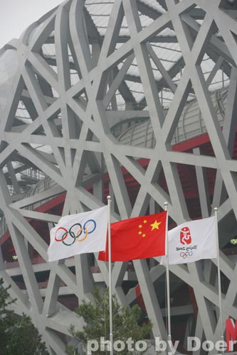 2008年8月24日，奥林匹克公园，北京奥运会当天闭幕。五星红旗、国际奥委会会旗、北京奥运会会徽旗在“鸟巢”前迎风飘扬。